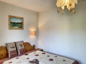 a bedroom with a bed and a chandelier at Charmant 2 pièces au centre de Combloux avec balcon, parking et proche ski bus - FR-1-560-2 in Combloux