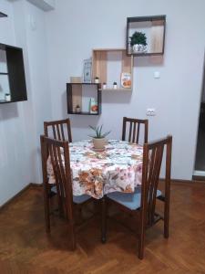 a dining room table with four chairs and a plant on it at Апартамент за гости, гр. Габрово - Център in Gabrovo