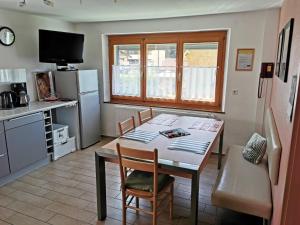 a kitchen with a table with chairs and a refrigerator at Haus Post EG-Wohnung in Todtnau