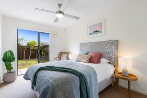 a bedroom with a bed with a blue blanket at Little Whale House in Mudjimba