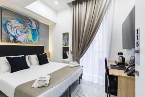 una camera d'albergo con 2 letti e una scrivania di Hotel Sant'Angelo Palace a Napoli