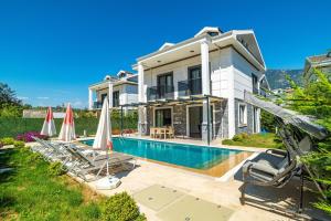 eine Villa mit Swimmingpool und ein Haus in der Unterkunft Hisarönü'de 4 Yatak Odalı Villa-Villa Bahama in Fethiye
