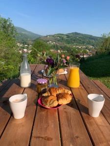 a table with a plate of croissants and orange juice at Balcons du Royans.Logement entier Piscine in Saint-Jean-en-Royans