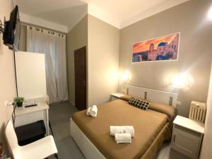 Golden Milano Hotel في ميلانو: غرفة نوم صغيرة بها سرير وكرسي