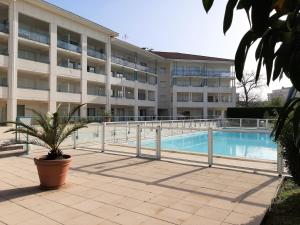 an apartment building with a swimming pool in front of it at Appartement Ciboure, 2 pièces, 4 personnes - FR-1-239-551 in Ciboure