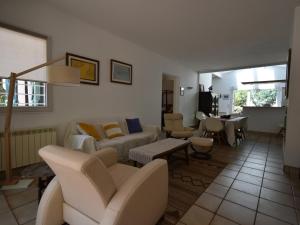 ein Wohnzimmer mit einem Sofa, Stühlen und einem Tisch in der Unterkunft Villa Pyla-sur-Mer, 5 pièces, 9 personnes - FR-1-420-94 in La Teste-de-Buch