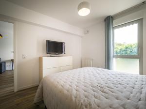 een slaapkamer met een bed en een tv aan de muur bij Appartement Saint-Jean-de-Luz, 2 pièces, 4 personnes - FR-1-239-522 in Saint-Jean-de-Luz