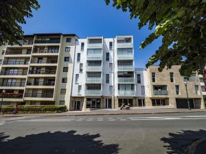 een groot wit appartementencomplex in een stadsstraat bij Appartement Saint-Jean-de-Luz, 2 pièces, 4 personnes - FR-1-239-522 in Saint-Jean-de-Luz