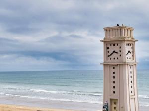 uma torre do relógio na praia perto do oceano em Appartement Les Sables-d'Olonne, 2 pièces, 4 personnes - FR-1-197-466 em Les Sables-dʼOlonne