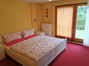 a bedroom with a large white bed with red pillows at Haus Post EG-Wohnung in Todtnau