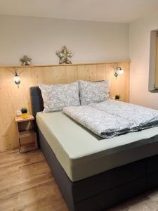 een slaapkamer met een groot bed met een houten hoofdeinde bij AmStein in Kaltenbach