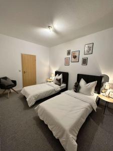 a bedroom with two beds and a desk and a chair at EICstay - Ferienhaus für Monteure und Familie in Worbis