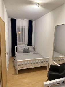 a bedroom with a white bed and a mirror at EICstay - Ferienhaus für Monteure und Familie in Worbis