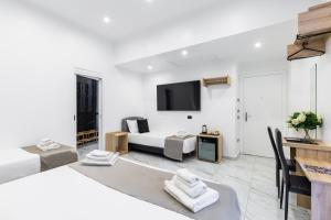 ナポリにあるHotel Sant'Angelo Palaceのベッド2台、壁掛けテレビが備わるホテルルームです。 +37枚の写真
