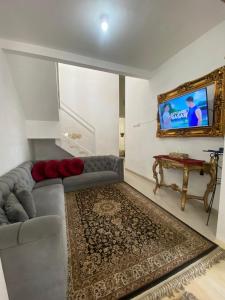 een woonkamer met een bank en een flatscreen-tv bij Villa Aslam Kayana Batu in Karangploso