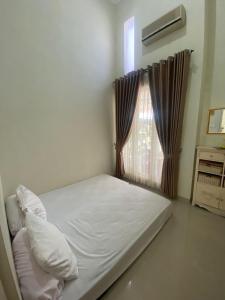 een bed in een kamer met een raam bij Villa Aslam Kayana Batu in Karangploso