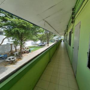 an empty hallway of a green building with a view of a street at Bangsaen Budget Hotel in Ban Samet