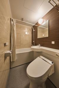 ein Badezimmer mit einem WC, einem Waschbecken und einer Badewanne in der Unterkunft Sekia Wagaya Hotel in Karahashi Rashomon