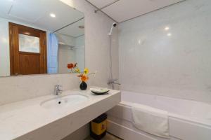 a bathroom with a sink and a mirror and a tub at Sumitomo8 Apartment &Residentce 68 Kim Mã Thượng in Hanoi