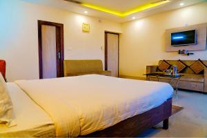 a bedroom with a large bed and a couch at FabHotel Kanchan Plaza in Bhubaneshwar