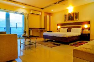 a bedroom with a bed and a living room at FabHotel Kanchan Plaza in Bhubaneshwar