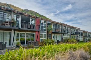 an apartment building with balconies and a mountain in the background at Lakeshore Studio at the Marina in Queenstown