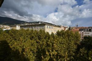 un edificio en una ciudad con árboles en primer plano en Hôtel Continental en Bastia