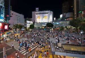 una multitud de personas cruzando una calle de la ciudad por la noche en Holiday Places /SHIBUYA 5min by train (Sangenjaya), en Tokio
