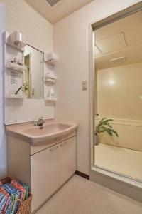 a bathroom with a sink and a mirror and a shower at Holiday Places /SHIBUYA 5min by train (Sangenjaya) in Tokyo