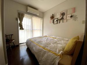 1 dormitorio con cama y ventana en Holiday Places /SHIBUYA 5min by train (Sangenjaya), en Tokio