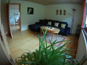 salon z niebieską kanapą i stołem w obiekcie Haus Post OG-Wohnung w mieście Todtnau