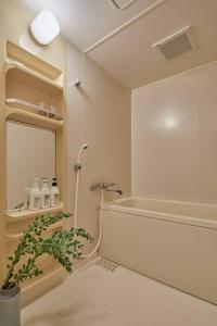baño con ducha y planta junto a un espejo en Holiday Places /SHIBUYA 5min by train (Sangenjaya), en Tokio