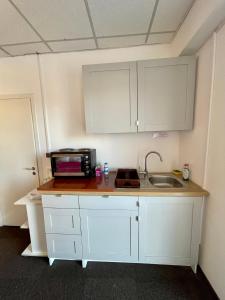 a kitchen with white cabinets and a sink at LuanaApartments # 43 in Otopeni