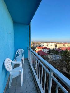 two white chairs sitting on a balcony with a view at LuanaApartments # 43 in Otopeni