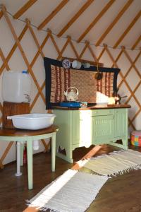 - une cuisine avec un évier et une table dans une chambre dans l'établissement Dzika Jurta na Łebkach, à Łebki