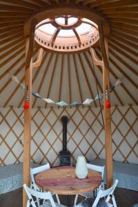 a table and chairs in a yurt with a window at Dzika Jurta na Łebkach in Łebki +12 photos