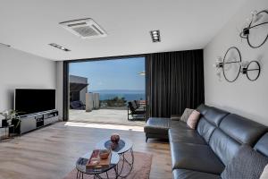 a living room with a couch and a tv at Villa Nina 2, Makarska in Makarska