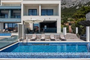 a villa with a swimming pool in front of a house at Villa Nina 2, Makarska in Makarska