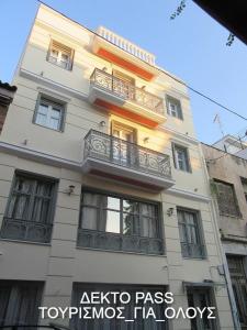 um edifício branco alto com uma varanda em UrbanStay em Atenas