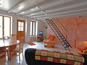 een woonkamer met een trap en een tafel bij Maison La Puye, 3 pièces, 4 personnes - FR-1-541-63 in La Puye