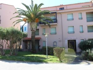 a palm tree in front of a pink building at Studio avec parking, terrasse ensoleillée et tennis à Collioure - FR-1-309-234 in Collioure