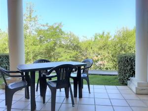 ein schwarzer Tisch und Stühle auf einer Terrasse in der Unterkunft Appartement T2 à Socoa avec terrasse, proche plage - FR-1-239-511 in Ciboure