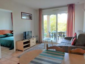 a living room with a couch and a tv at Appartement Ciboure, 2 pièces, 4 personnes - FR-1-239-511 in Ciboure