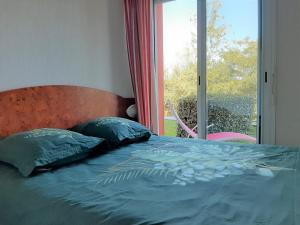 a bedroom with a bed with a large window at Appartement Ciboure, 2 pièces, 4 personnes - FR-1-239-511 in Ciboure