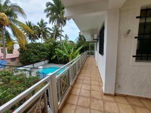 einen Balkon mit Blick auf den Pool und die Palmen in der Unterkunft hamdan retreat villa in Grand Baie