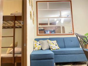 - un canapé bleu dans un dortoir avec des lits superposés dans l'établissement Resort-type 2 bedroom Unit by OneOasisHaven, à Cagayán de Oro
