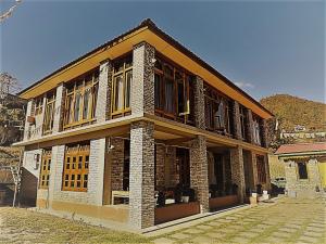 Dirang DzongにあるKharjap Homestayの大きな窓のある大きな建物