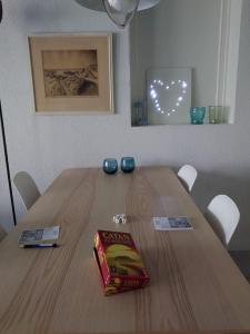 a wooden table with a book on top of it at De Oostkamer; Eiland appartement naast natuurgebied Boschplaat in Oosterend