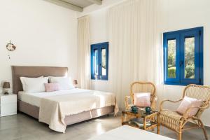 a bedroom with a bed and a chair at Alasthas in Gavrio +37 photos