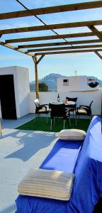 a patio with a table and chairs under a roof at Costa de Granada Calle peatonal in Salobreña